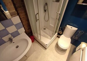 Een haardroger, handdoeken, zeep, toiletpapier