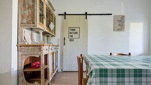 Una stanza con un armadio in legno, un letto con copriletto a quadretti, una porta con una citazione motivazionale e un lampadario fissato al muro.
