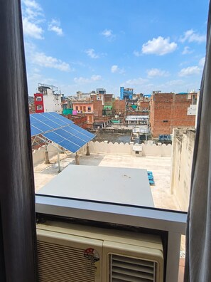 A rooftop with solar panels and a view of a densely built urban area. - Shree Hari Kunj (Varanasi)
