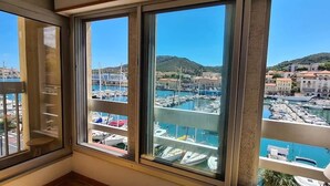 Une chambre avec vue sur un port de plaisance et des immeubles.