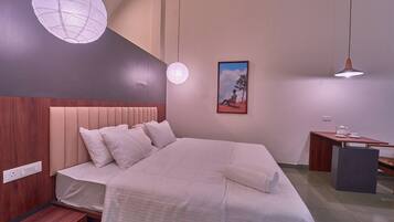Ein modernes Schlafzimmer mit einem großen Bett, Nachttischen, einem Schreibtisch und einer Pendelleuchte.