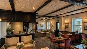 A spacious room with a high ceiling, exposed beams, and a bar area. - Nent Hall Country House Hotel (Alston)