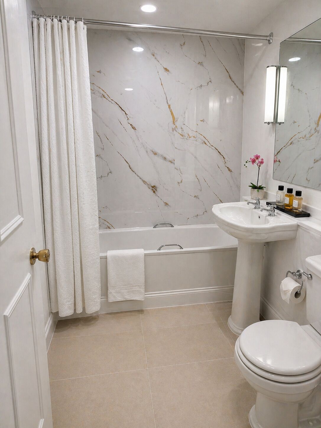 Ein Badezimmer mit einer Badewanne, einem Waschbecken, einer Toilette und einer Marmorwand.