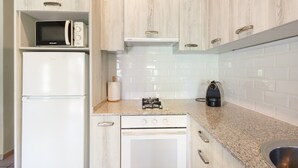 A kitchen with white cabinetry, a microwave, a refrigerator, a stove, and a sink. - Rural Apartment El Corral 1 (Lladurs)