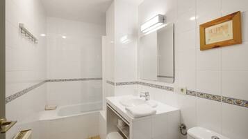 A bathroom with a bathtub, a sink, a toilet, and a shower.
