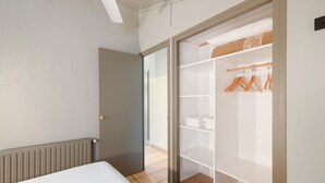 Et soveværelse med seng, garderobe og radiator.