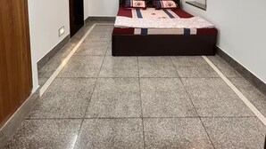 A bedroom with a bed, a ceiling fan, a wall-mounted air conditioner, and a light fixture. - Narpati Villa (Jodhpur)