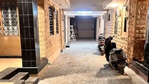 A narrow corridor with tiled flooring and brick walls, leading to a door at the end. - Narpati Villa (Jodhpur)