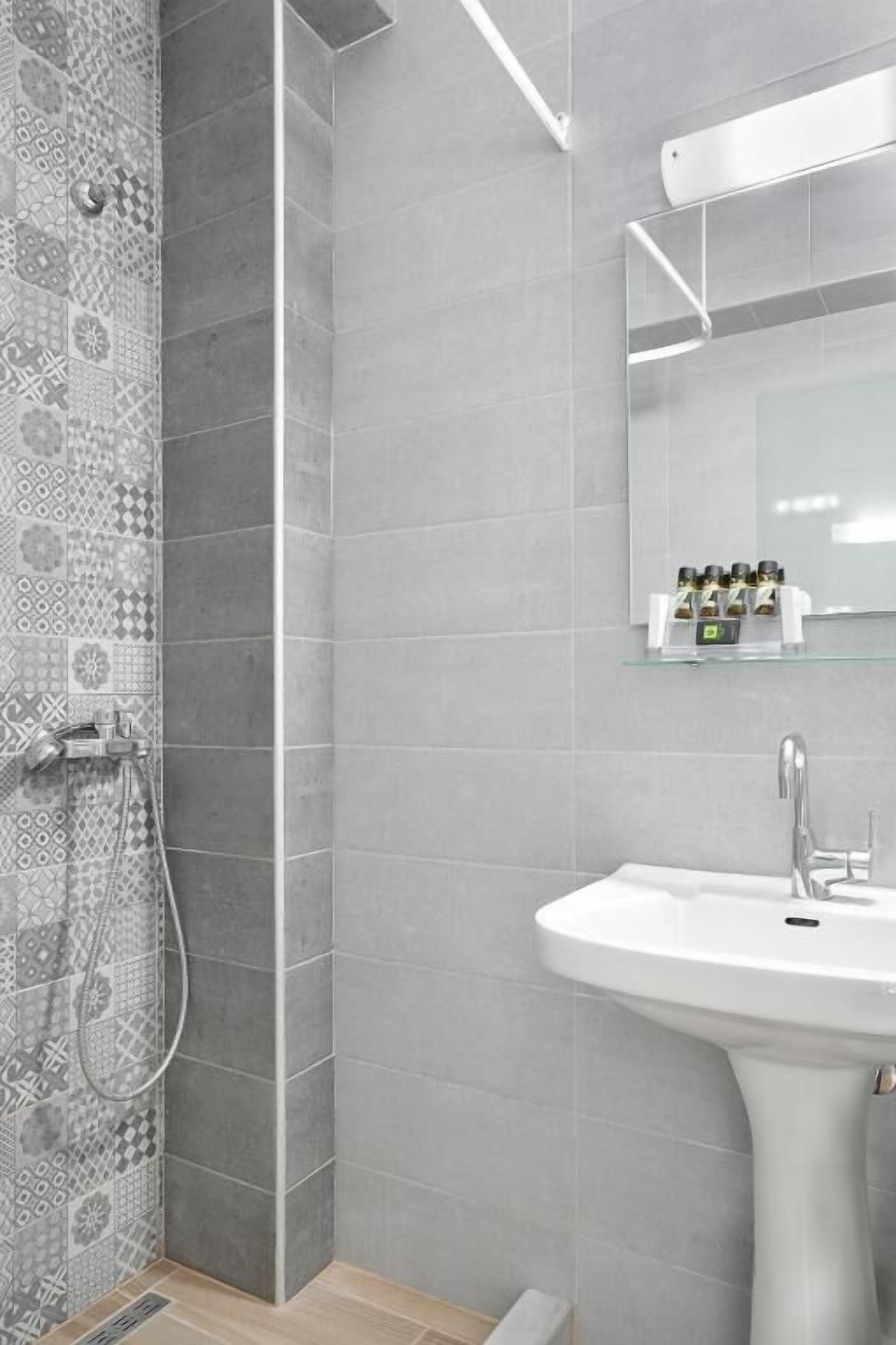 Un baño moderno con ducha, lavamanos y espejo.