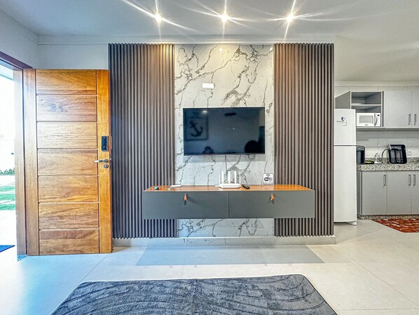 A modern kitchen with a built-in microwave, a coffee machine, and a sink. - Residencial Saint Loius (Porto Seguro)