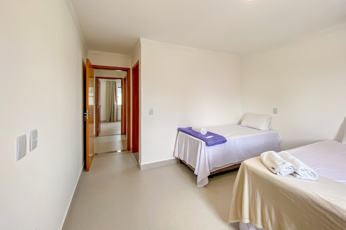 Un dormitorio con cama, baño y pasillo.