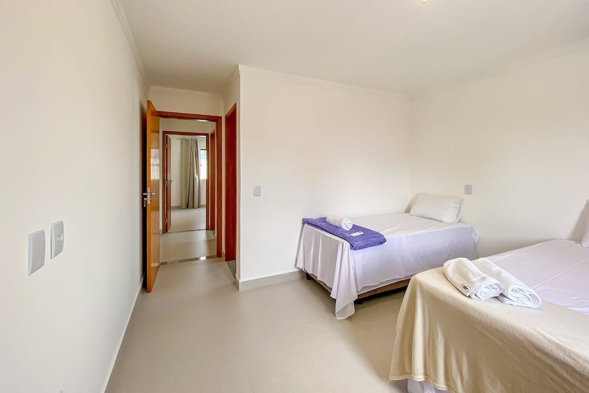 A bedroom with a bed, a bathroom, and a hallway.