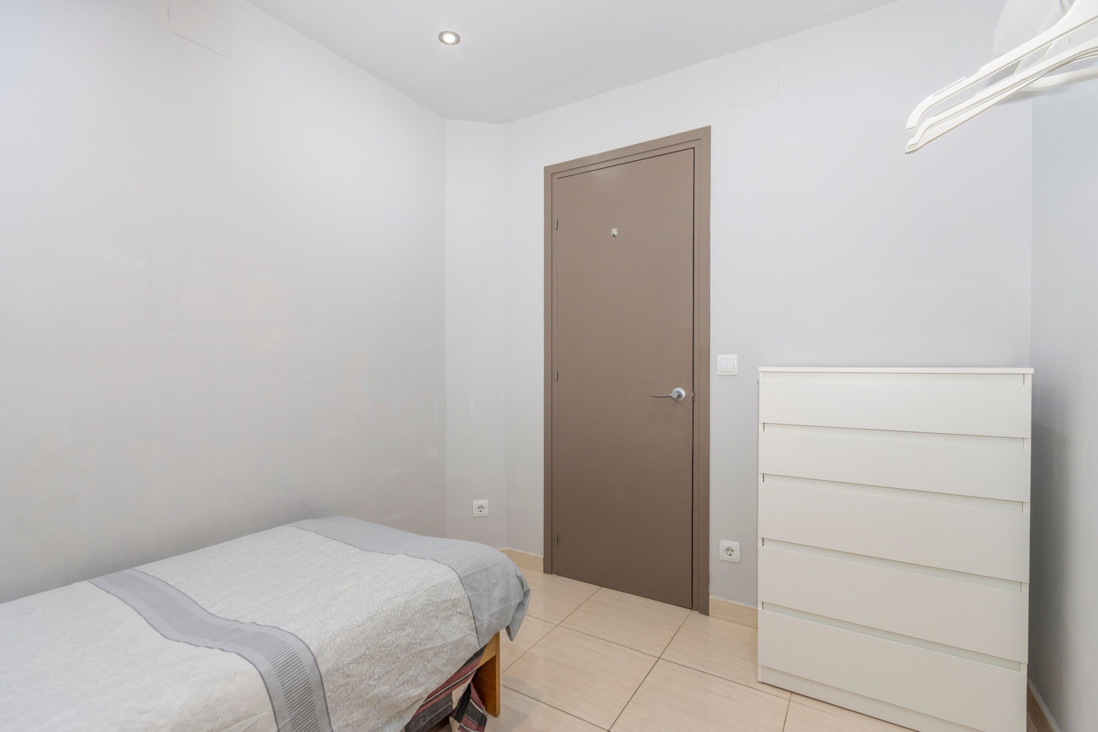 Ein Schlafzimmer mit einem Bett, einem Kleiderschrank und einer Tür.