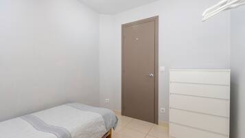 Ein Schlafzimmer mit einem Bett, einem Kleiderschrank und einer Tür.