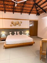 Un dormitorio con cama, ventilador de techo, apliques de pared y una puerta.