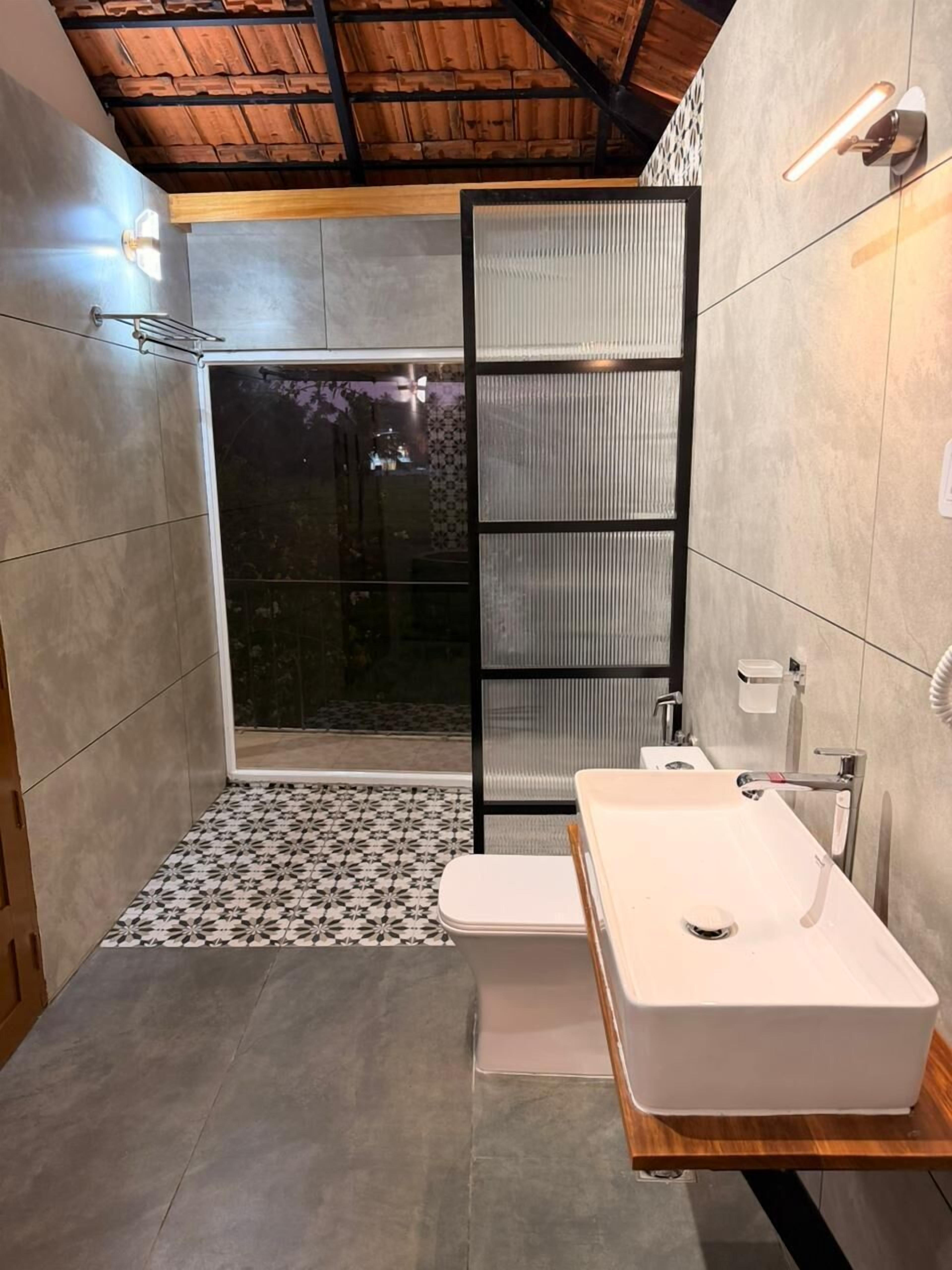 Ein modernes Badezimmer mit Dusche, Toilette und Waschbecken, mit Holzboden und Fliesenböden.