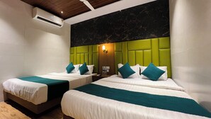 A hotel room with two beds, a ceiling fan, and an air conditioning unit. - Hotel Imperial Suite (Mumbai)
