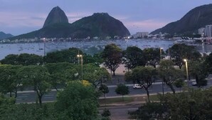 Un paysage urbain avec une montagne imposante et une étendue d’eau.