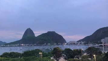 Paisagem urbana com uma montanha imponente e um corpo d'água.
