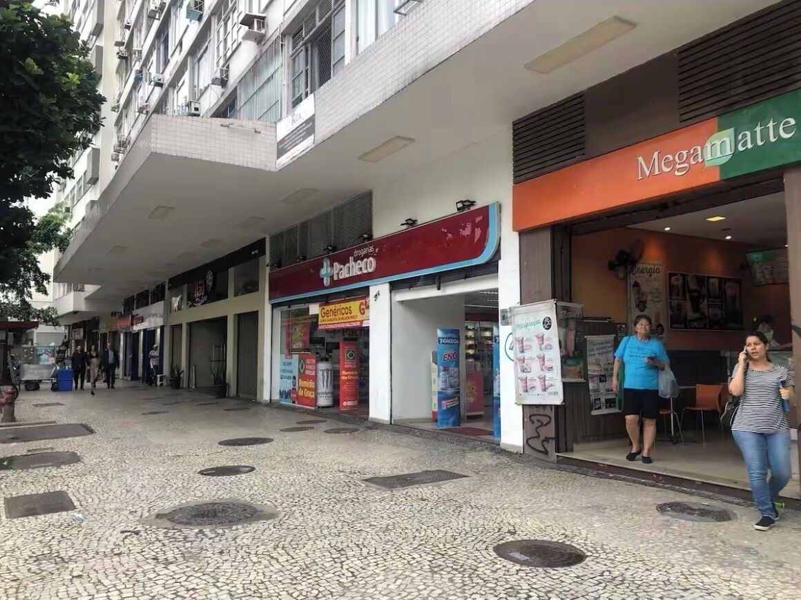 A pedestrian area with shops, including a pharmacy and a café.