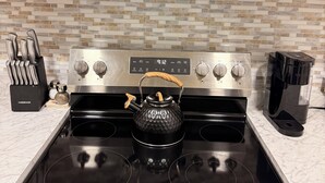 Une cuisine équipée d’un four à micro-ondes, d’une cuisinière et d’une bouilloire.