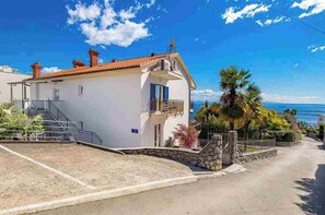 A coastal house with a stone entrance, a balcony, and a view of the sea. - 2 bedroom Apartment Victoria with panoramic views (Ičići)