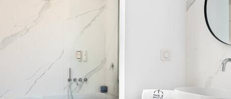 Un baño con bañera, ducha y lavabo con espejo.