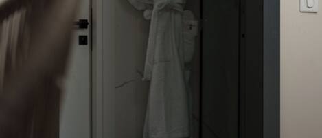 A white door with a handle and a small light switch on the wall.