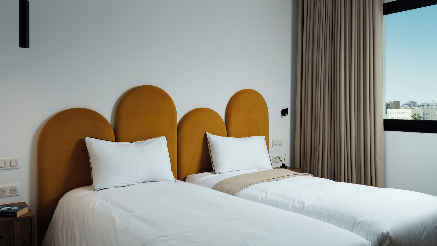 A double bed with a wooden headboard and two white pillows.