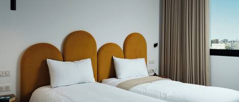 A double bed with a wooden headboard and two white pillows.