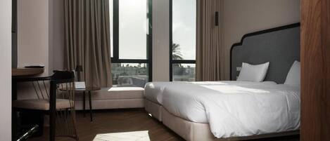 A hotel room with a bed, a desk, and a chair.