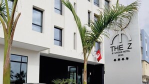 Un edificio moderno con un cartel que dice "The Z Boutique Hotel" y una calificación de cinco estrellas.
