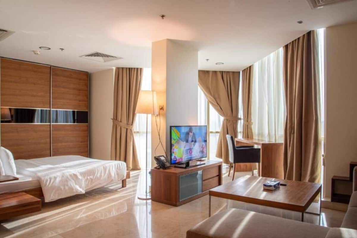Une chambre d’hôtel avec un lit, une télévision, un bureau et une chaise.