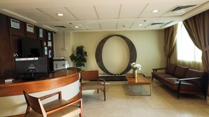 Eine moderne Lobby mit Empfangstresen, Sitzgelegenheiten und einer großen Wandgestalt.