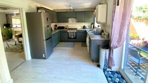 A compact kitchen with grey cabinets, a stainless steel refrigerator, and a small island. - Charming Cottage Overlooking River & Nr Town /FREE Parking (Maidstone)