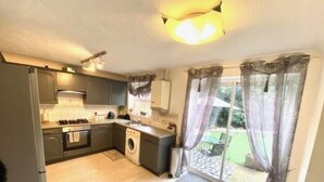 A compact kitchen with a washing machine, a sink, and a stove. - Charming Cottage Overlooking River & Nr Town /FREE Parking (Maidstone)