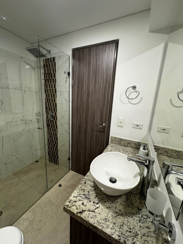 Een douche, handdoeken, zeep, toiletpapier
