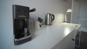 A modern hotel room with a coffee maker, a kettle, and a lamp on the counter. - The Southport Two-Bed @ Stay Victoria Suites (Merseyside)