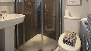 A bathroom with a glass-enclosed shower, a toilet, and a sink. - The Southport Two-Bed @ Stay Victoria Suites (Merseyside)