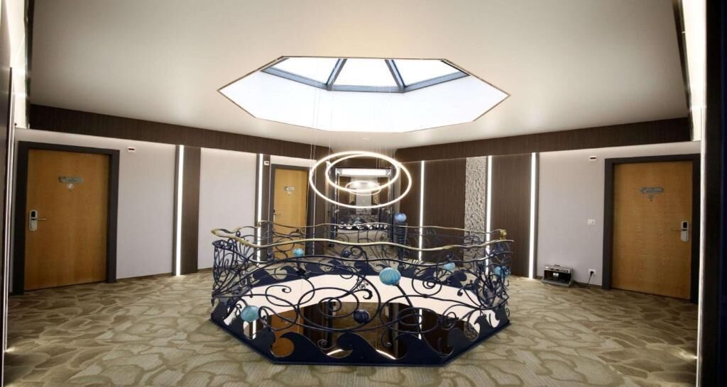 Een hotelkamer met een dakraam, een decoratief metalen middelpunt en een vloerbedekking.