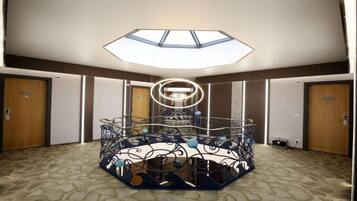 Een hotelkamer met een dakraam, een decoratief metalen middelpunt en een vloerbedekking.