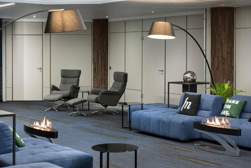 A modern lounge area with seating, a fireplace, and ambient lighting.