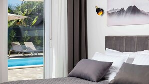 Ein Schlafzimmer mit Bett, Kissen, einer Wandlampe und einem Gemälde.
