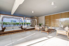 Una sala moderna con un conjunto de sofás, una mesa de centro y una pared decorativa de piedra.