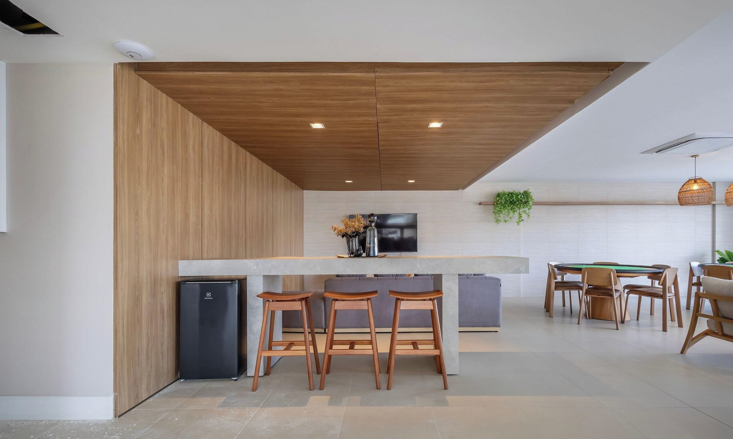Eine moderne Küche mit Holzbalkendecke, einem integrierten Kühlschrank, einer Bar mit Barhocker und einem Billardtisch.