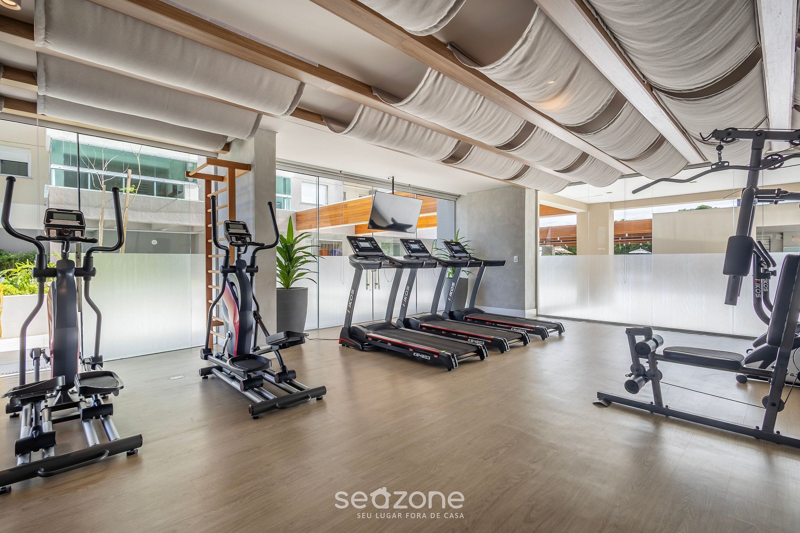 Un gimnasio moderno con cintas de correr, elípticas y equipo de pesas.