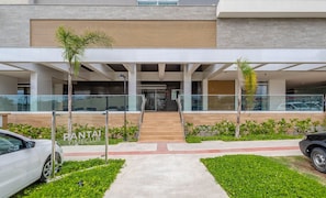 Un edificio moderno con entrada cubierta, barandillas de vidrio y un letrero que dice "FANTAI HOMECLUB".