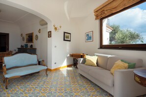Ein Zimmer mit einer Couch, einer Bank und einer Nähmaschine.