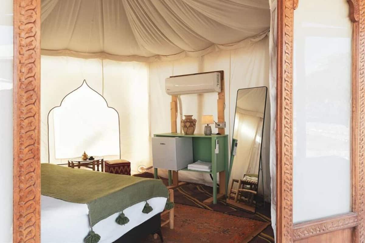 Une chambre comprenant un lit, un bureau, une chaise, un miroir et un appareil de climatisation.