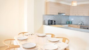 Un comedor con una mesa redonda dispuesta para seis personas, con platos, vasos y cubiertos.